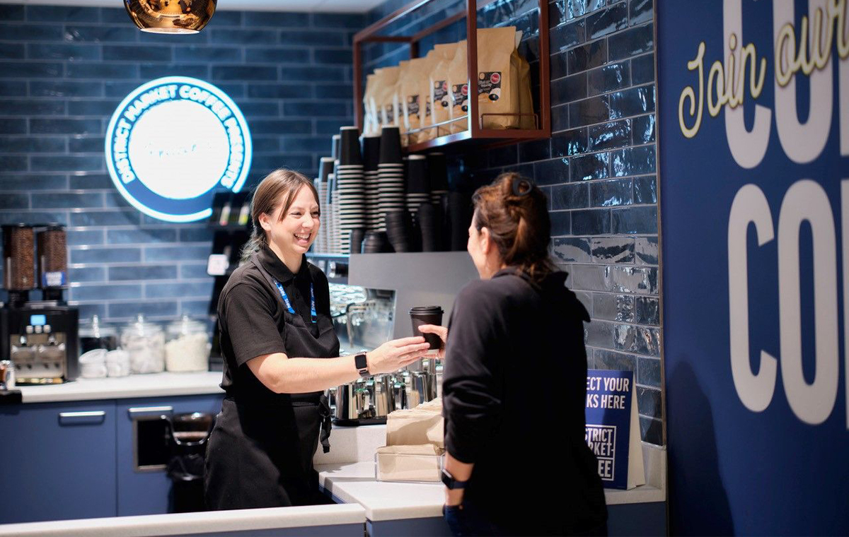 Barista serving a customer in District Market Coffee